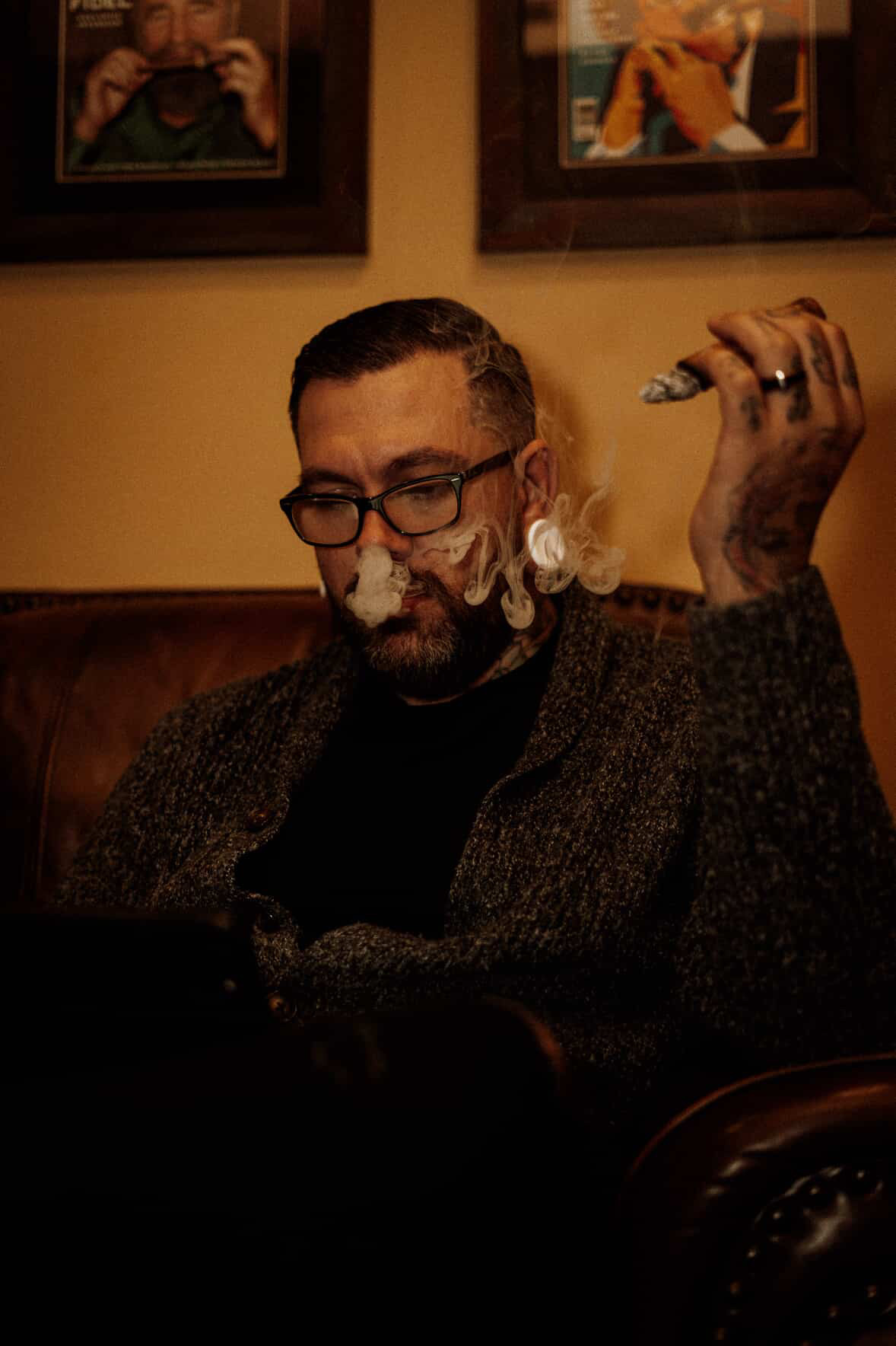 Portrait of George Weibe seated with a cigar